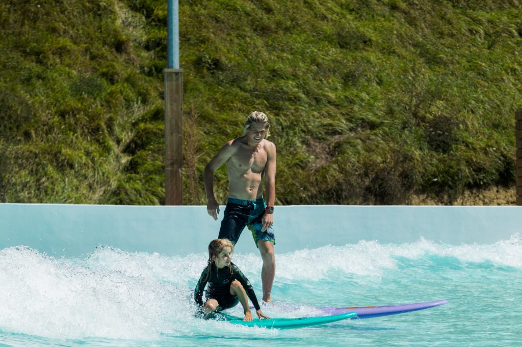 father and son wave pool surfing