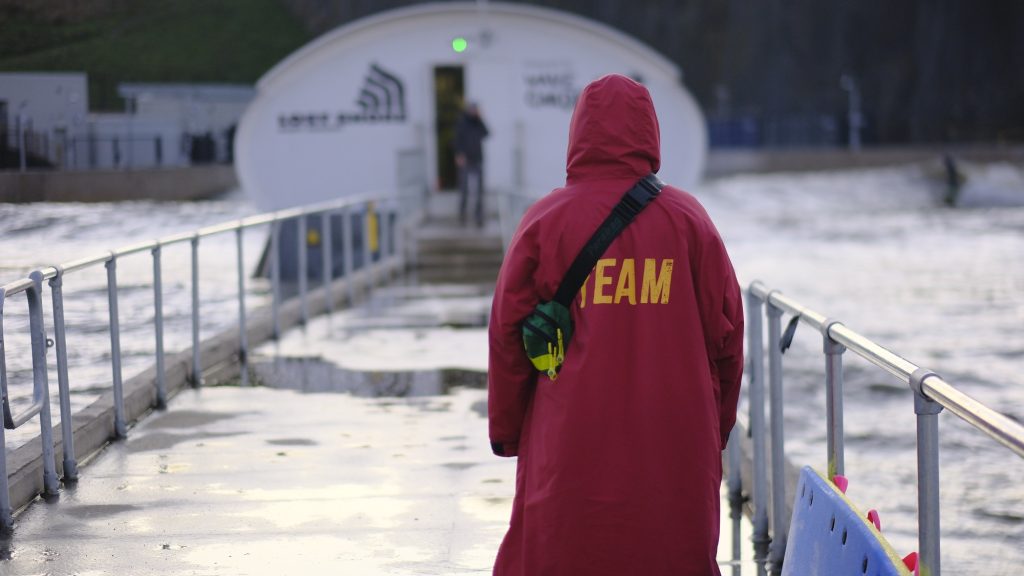 A lifeguard at Lost Shore Surf Resort overseeing surfers in the wave pool, ensuring safety at Europe’s largest surf park.