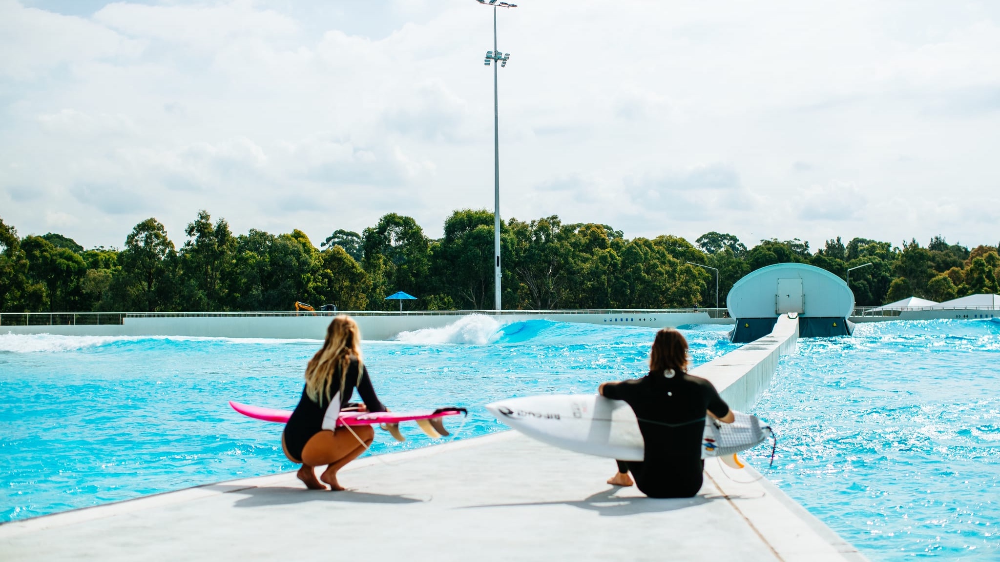 thriving surf park with surfers, families, and visitors enjoying artificial waves