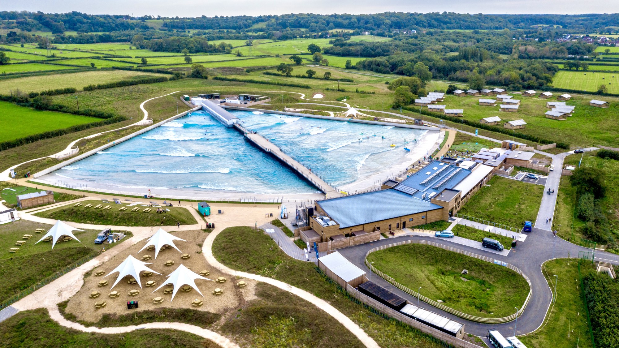 wave pool travel to the wave bristol: image shows a drone's view of the wave pool and surrounding land complete withe camping area